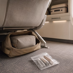 Kosmetiktasche im Handgepäck unter einem Flugzeugsitz Wohin mit meiner Kosmetiktasche während des Fluges? Handgepäck-Regeln für Handgepäck-Regelnde